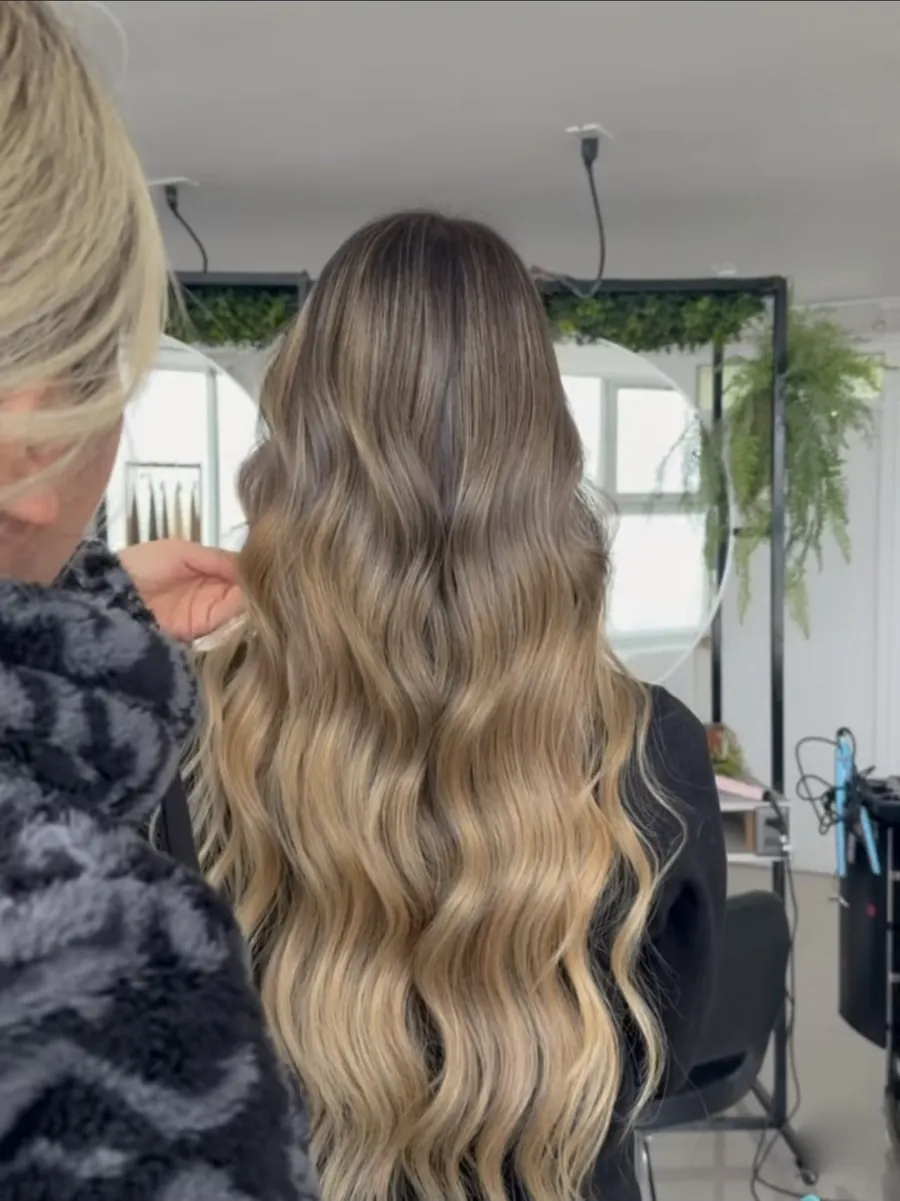 Balayage rubio tostado en cabello largo ondulado